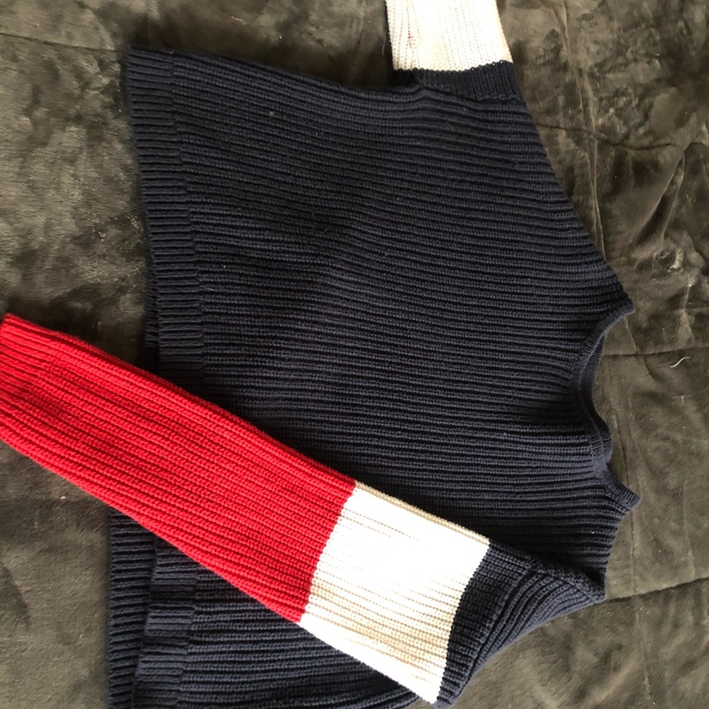 Blue sweater with red and white sleeves